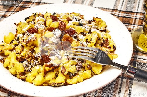 Image of  cut-up and sugared pancake with raisins
