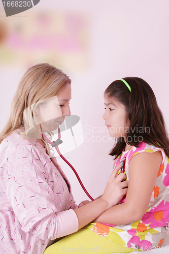 Image of Female doctor examining little girl 