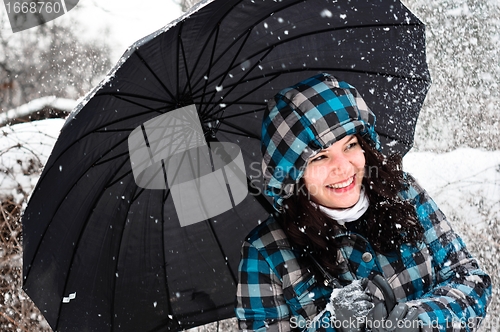 Image of Young woman with umbrella in a blizzard