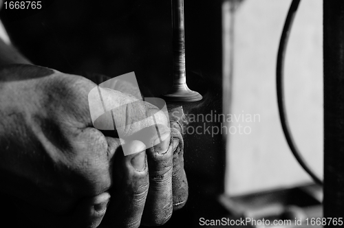 Image of Hands of a worker polishing metal