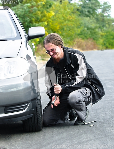 Image of Handsome young man repairing car