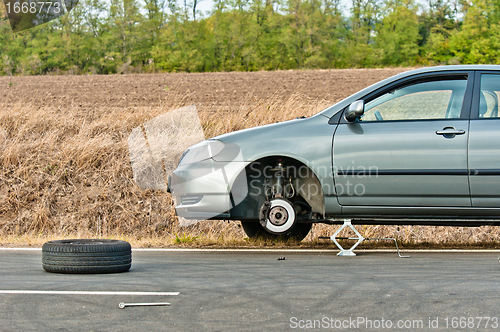 Image of Car without tire on the road