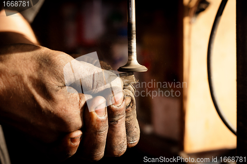 Image of Hands of a worker polishing metal