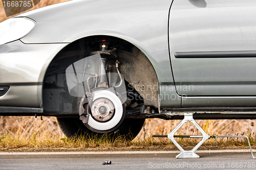 Image of Car without tire on the road