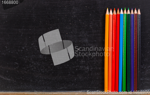 Image of Colorful pencils against chalk board