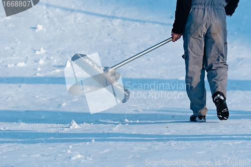 Image of Male worker cleaning the road from the snow