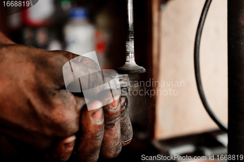 Image of Hands of a worker polishing metal