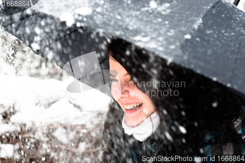 Image of Young woman with umbrella in a blizzard