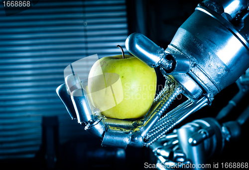 Image of A robot hand holding a fresh apple