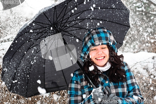 Image of Young woman with umbrella in a blizzard