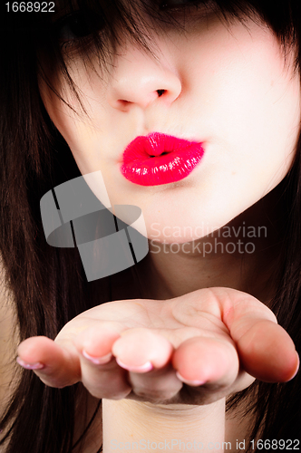 Image of Beautiful young girl throwing a kiss at you