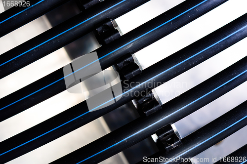 Image of Black plastic pipes against white background