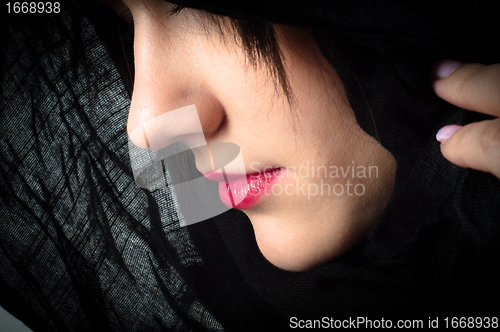 Image of Closeup photo of a woman in black hood and red lips