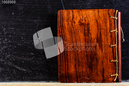 Image of Wooden Book against black chalkboard