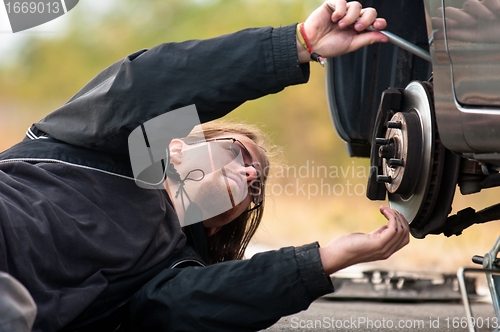 Image of Handsome young man repairing car