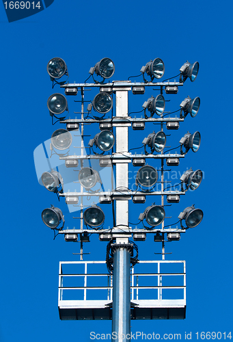 Image of Stadium lighting with a lot of reflectors against blue sky