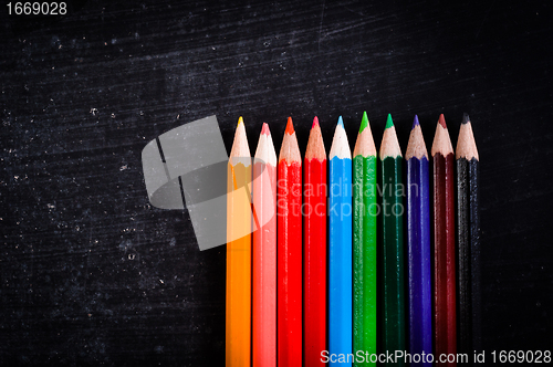 Image of Colorful pencils against black chalkboard