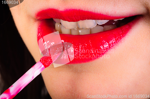 Image of Girl putting on red lipstick