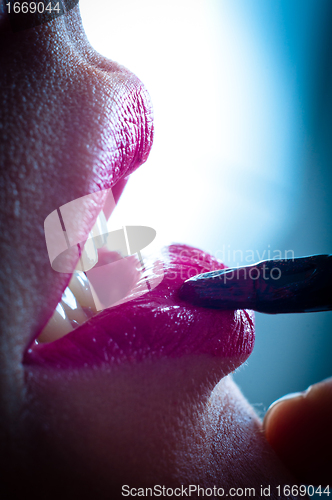 Image of Girl putting on red lipstick