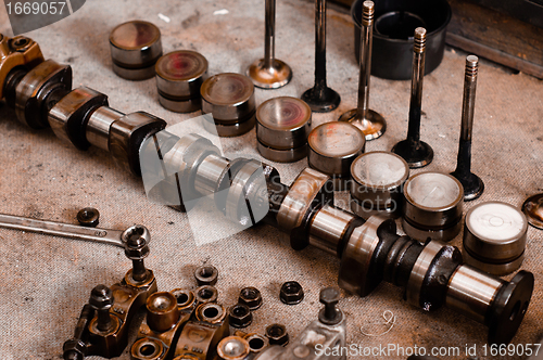 Image of Greasy motor block parts on wooden plate