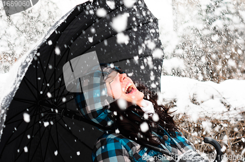 Image of Young woman with umbrella in a blizzard