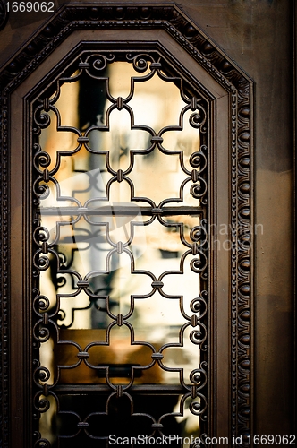 Image of Old window with reflection and steel cage