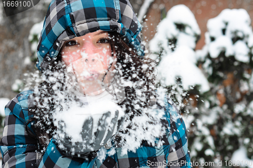 Image of Attractive young woman with snow in her hand