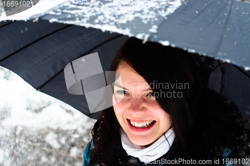 Image of Young woman with umbrella in a blizzard