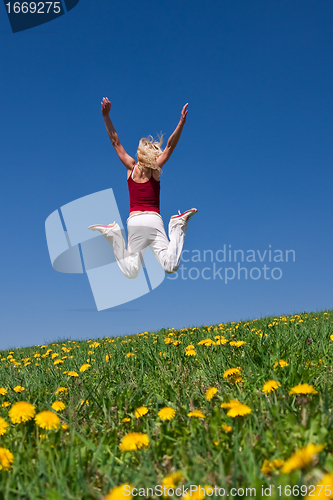 Image of young woman in red outfit having fun on meadow