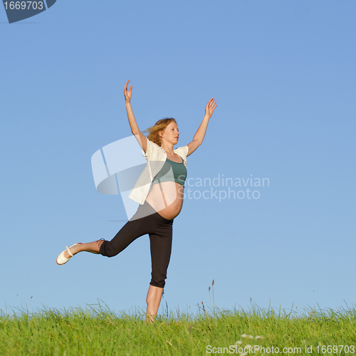 Image of pregnant woman on meadow