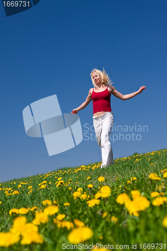 Image of young woman in red outfit having fun on meadow