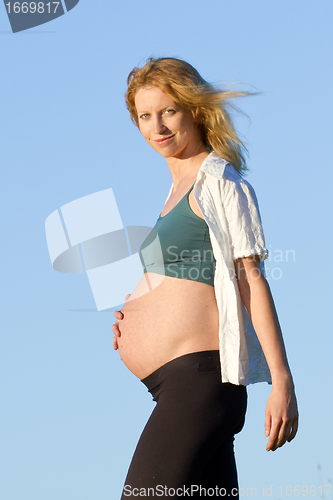 Image of pregnant woman on meadow