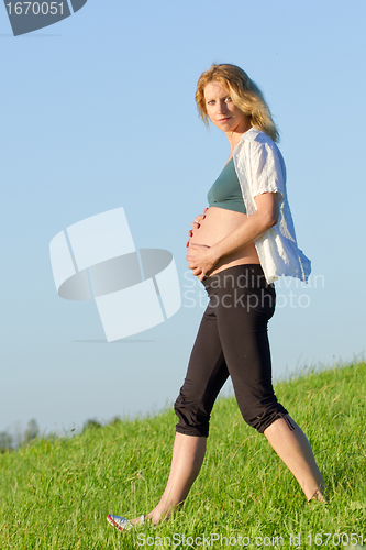 Image of pregnant woman on meadow