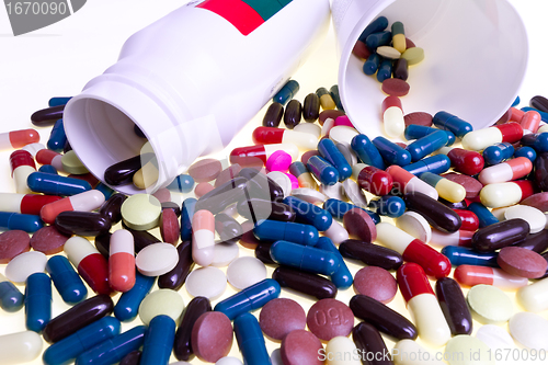 Image of pills spilling out of container 