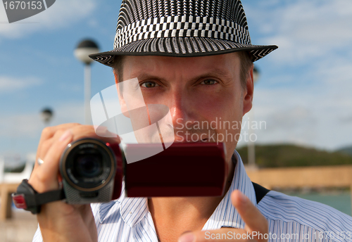 Image of man in a hat with a camera