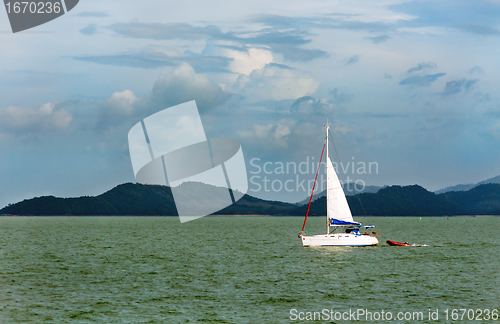 Image of white sailboat in the background of the tropical islands