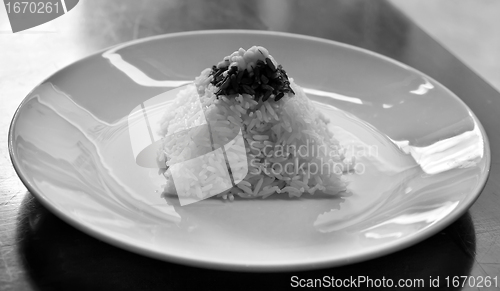 Image of pyramid of rice on a plate in a restaurant with a worn table