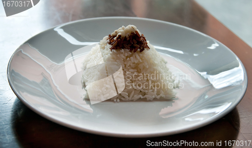 Image of pyramid of rice on a plate in a restaurant with a worn table