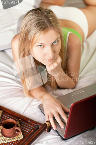Image of woman in bed with laptop