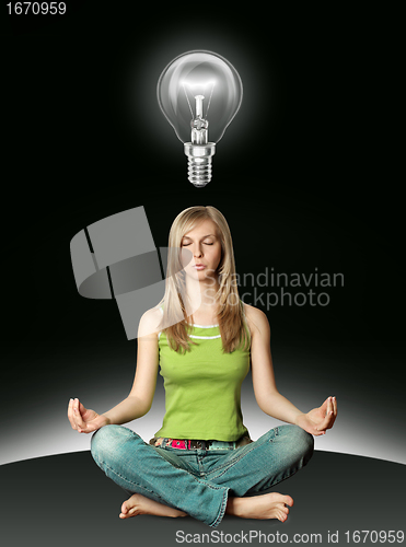 Image of woman meditation in lotus pose with bulb