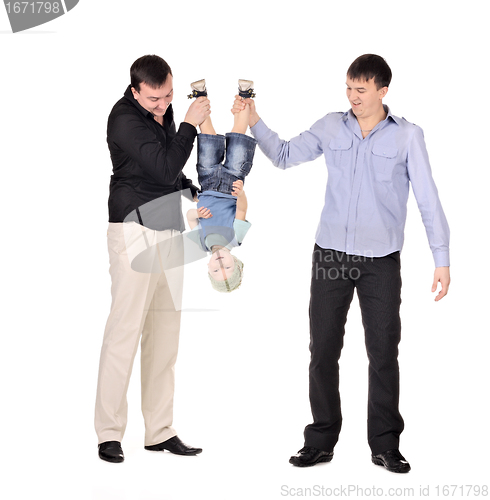 Image of Two gusd holding little boy upside down