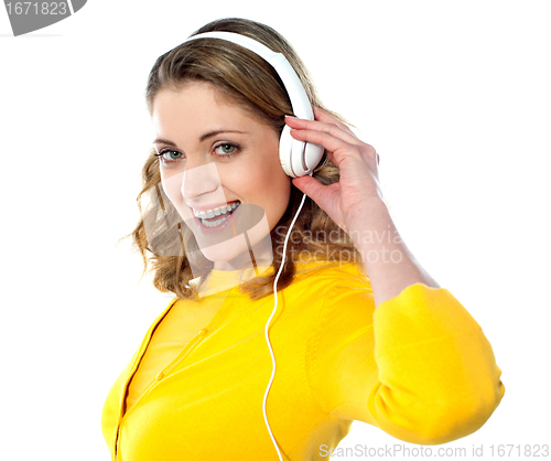 Image of Beautiful young woman with headphones listening music