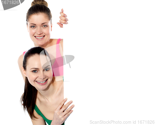 Image of Two attractive girls holding blank whiteboard