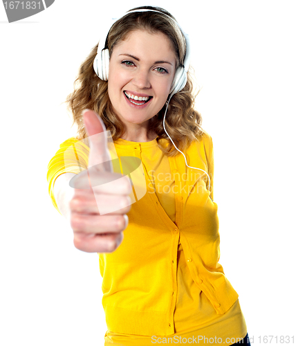 Image of Thumbs-up woman enjoying music