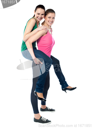 Image of Teenage girl piggybacks her friend