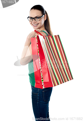 Image of Side view of woman holding shopping bags