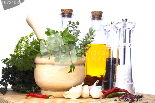 Image of Mortar and pestle with fresh herbs, spices, virgin olive oil, sa