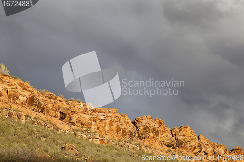 Image of stormy sky over sandstone cliff