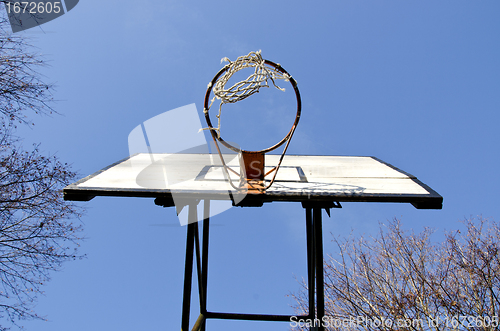 Image of Basketball board with old tattered net on hoop 