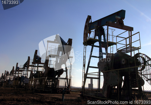 Image of many working oil pumps silhouette